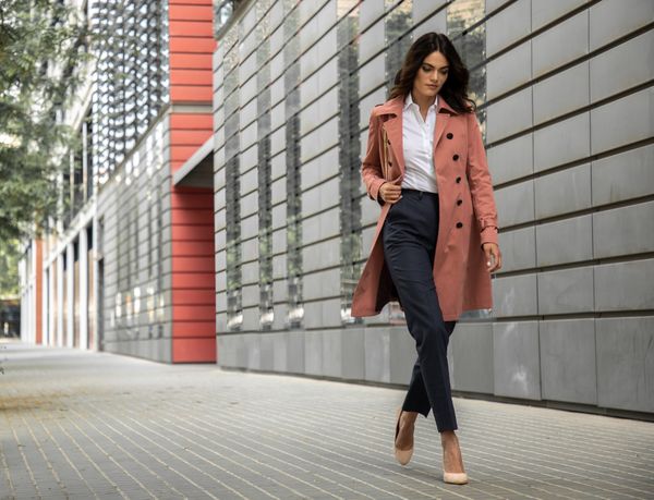 woman walking in pink trench coat