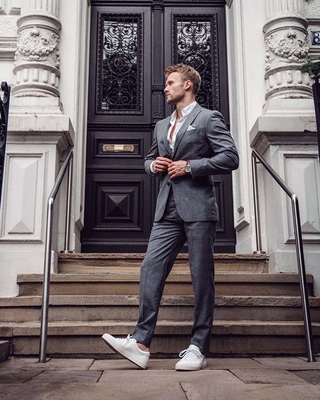 Man posing in white sneakers and striped suit