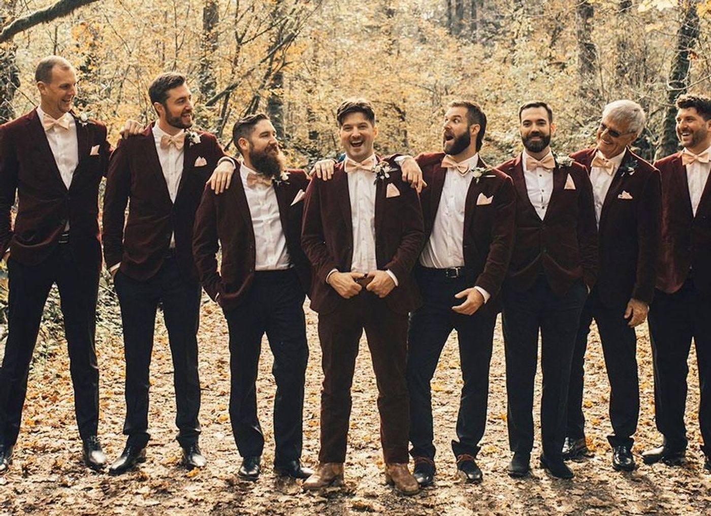 Groom and seven groomsmen dressed in red velvet tuxedos